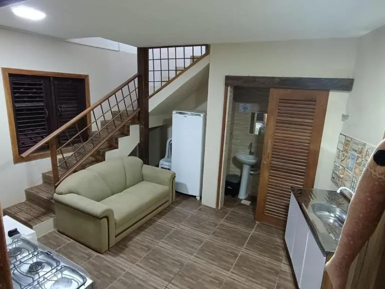 Sala do apartamento com sofá e escada